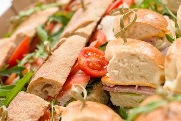 Gourmet sandwich platter with fresh baguettes, tomatoes, and arugula