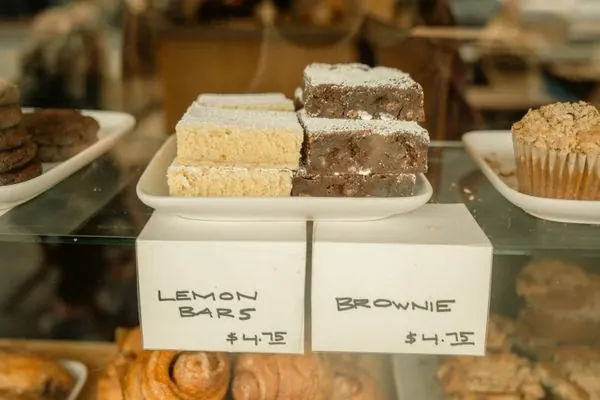 Bakery display case with lemon bars, brownies, and fresh pastries