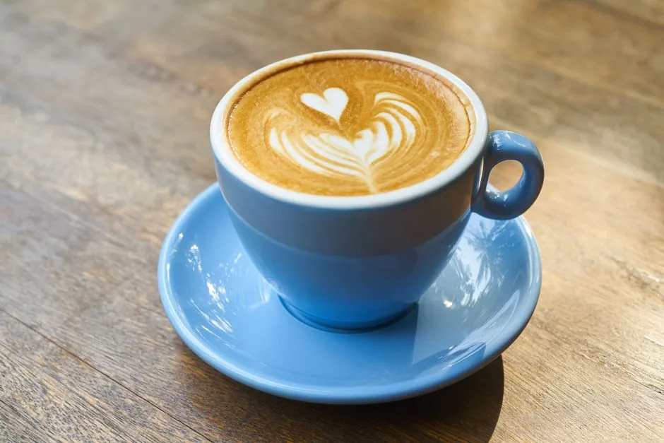 Heart-shaped latte art poured carefully into a white ceramic cup